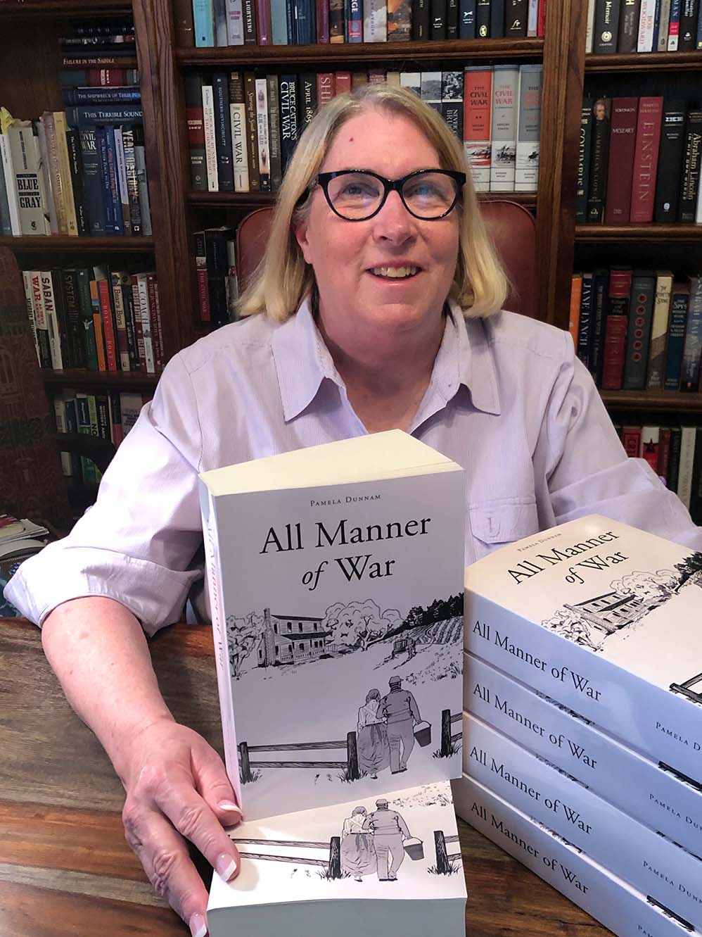 Author with stacked copies of her book.